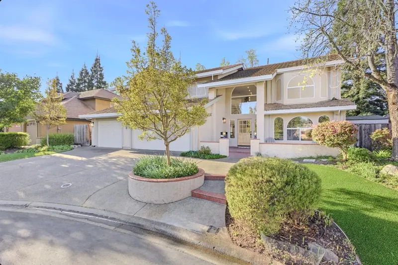 Two-story home with a landscaped front garden and mature trees